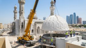 Installation crew lifting a curved GRC dome panel into position with a crane at a mosque site in Dubai