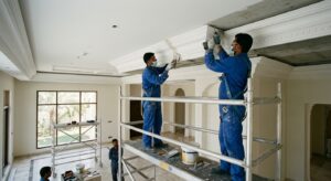 Technicians fixing and jointing GRG cornices on a villa ceiling during professional installation